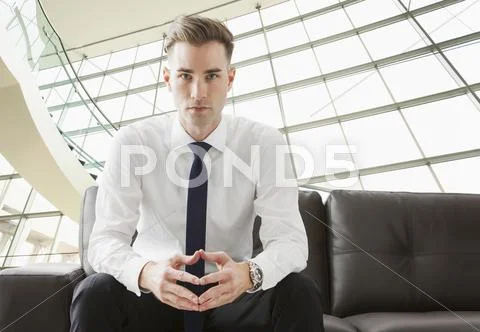 Caucasian Businessman Sitting On Sofa In Lobby
