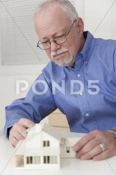 Caucasian businessman working on model of house Stock-Fotos