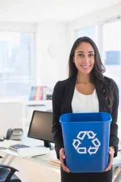Caucasian businesswoman holding recycle bin Stock Photos