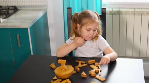 Caucasian child is arranging and stacking wooden cubes on a table Stock Footage 320333978