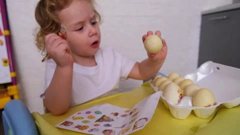 Caucasian child decorating Easter eggs with stickers. Kid prepares boiled e.. Stock-Footage 330108814