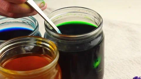 A Caucasian child paints a small Easter quail egg in a speck, dips it with a Stock Footage 148189617