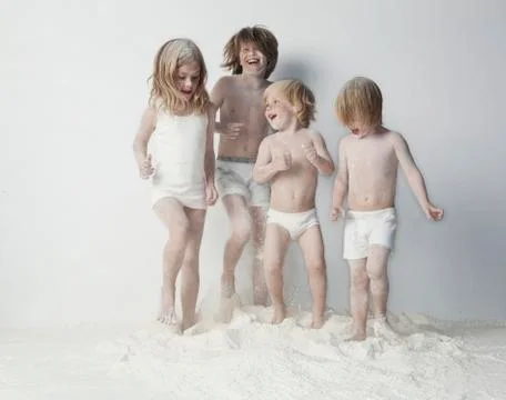 Caucasian children playing in flour Stock Photos
