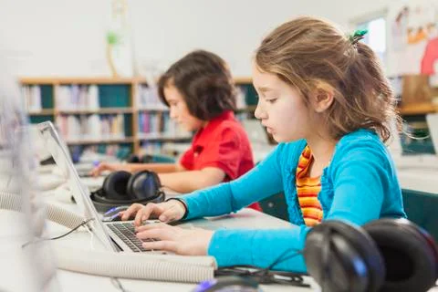 Caucasian children using laptops in library 写真素材