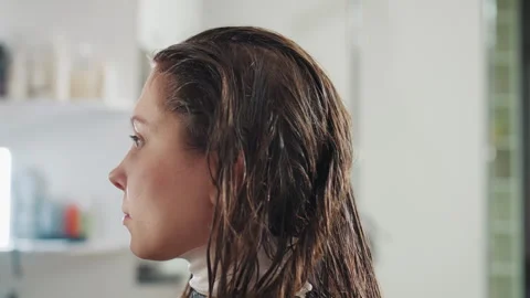 Caucasian client side profile with wet hair sits in salon mirror reflection Stock Footage 321654458