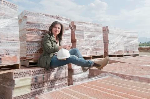 Caucasian construction worker sitting on stack of bricks Stock Photos