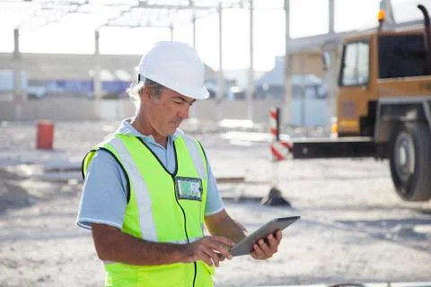 Caucasian construction worker using digital tablet at construction site Stock Photos