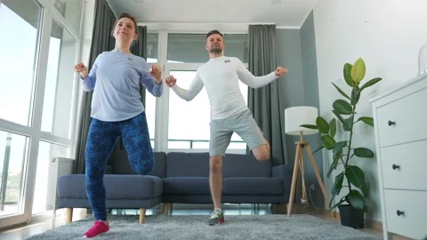Caucasian couple is doing cardio exercise at home in cozy bright room. Stock Footage 155478411