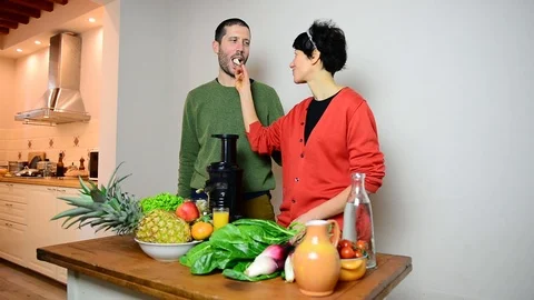 Caucasian couple joking while preparing fresh and healthy vegetables juice 스톡 동영상 122300444