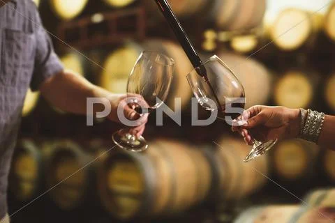 Caucasian couple tasting wine in cellar Stock Photos