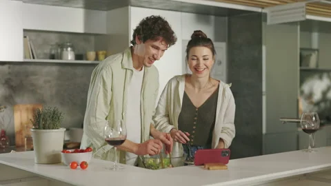 Caucasian couple using smartphone while cooking at home Stock Footage 169923568