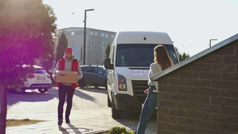 Caucasian courier carry parcel boxes on a trolley from a van and give it to a Stock Footage 166351464