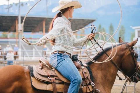 Caucasian cowgirl twirling lasso in rodeo Stock Photos