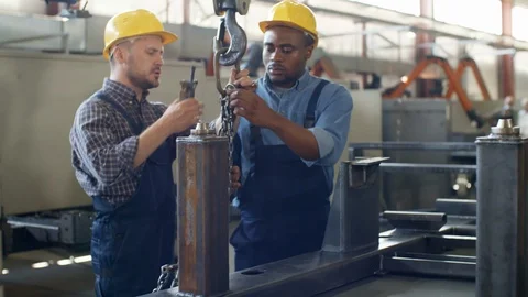 Caucasian crane operator instructing black trainee Stock Footage 106254944
