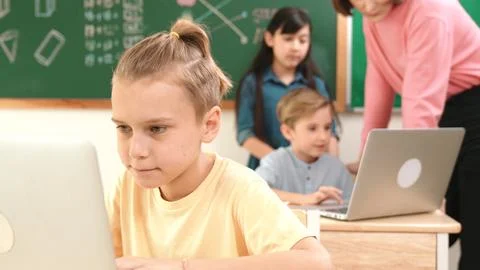 Caucasian cute boy focus on programing system while writing program. Pedagogy. Photos