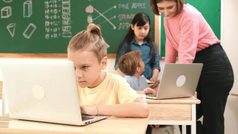 Caucasian cute boy focus on programing system while writing program. Pedagogy. Photos