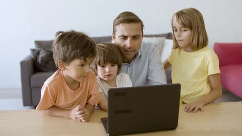 Caucasian dad watching movie via laptop with kids Stock Footage