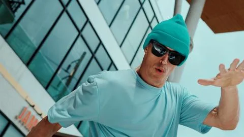 Caucasian dancer looking at camera while dancing at sky scrapper. Hiphop. Stock Photos