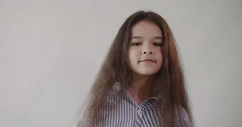 Caucasian dark haired long haired girl with loose hair shakes her head playfully Vídeo Stock 137973586