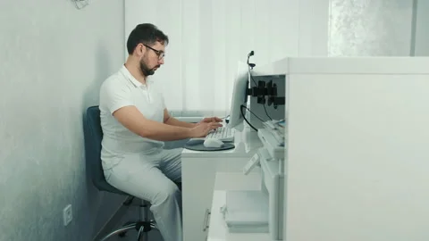 Caucasian dentist sitting at the computer at the reception and recording the Stock Footage 150929324