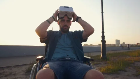 Caucasian desability man in wheelchair using virtual reality headset at sunny Stock Footage 110218533