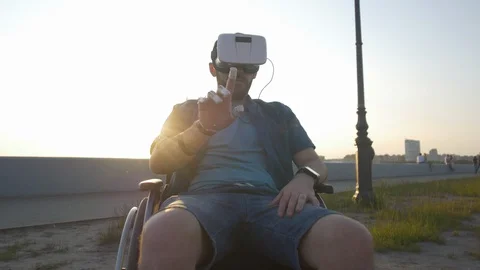 Caucasian desability man in wheelchair using virtual reality headset at sunny Stock Footage 110219488