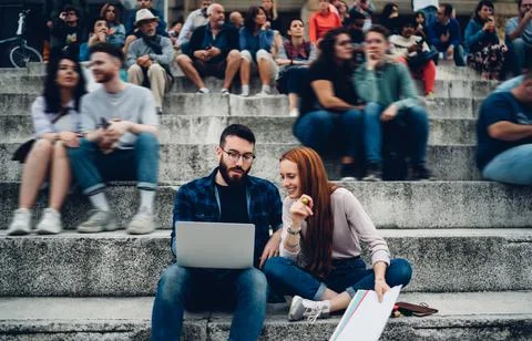 Caucasian digital nomad browsing wireless publication while collaborating on Stock Photos