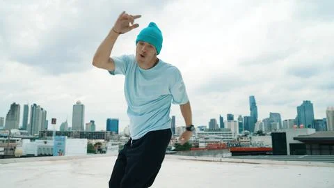 Caucasian energetic B-boy dancer practicing street dancing at rooftop. Endeavor. 库存照片