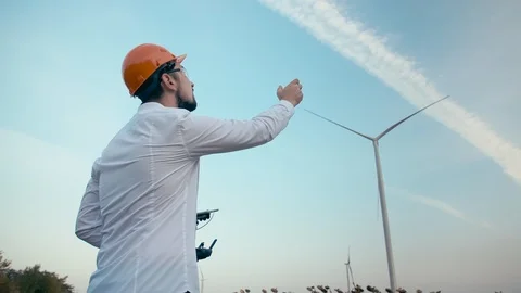 Caucasian engineer with a beard in an orange protective helmet and goggles Stock Footage 99582691