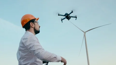 Caucasian Engineer in an orange protective helmet and goggles with a remote Video stock 96770588