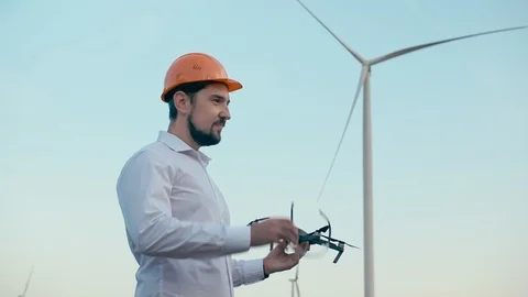 Caucasian Engineer in an orange protective helmet and goggles with a control Stock Footage 96770853