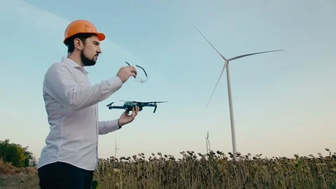 Caucasian engineer in an orange protective helmet puts on goggles and launches a Stock Footage 99581490