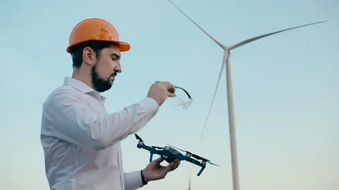 Caucasian Engineer in an orange protective helmet and goggles with a control Video stock 99582345