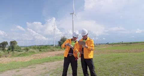 Caucasian engineers coordinate drone flight for wind turbine inspection outdoor Stock Footage 335219452