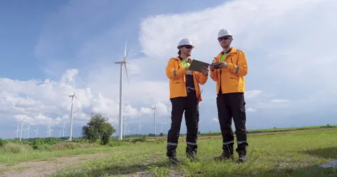 Caucasian engineers operate drone at wind farm reviewing live data on tablet Stock Footage 321046774