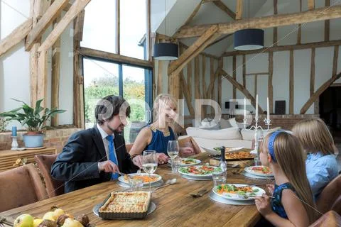 Caucasian Family Eating Dinner In Dining Room