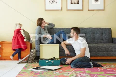 Caucasian Family Listening To Vinyl Records In Living Room