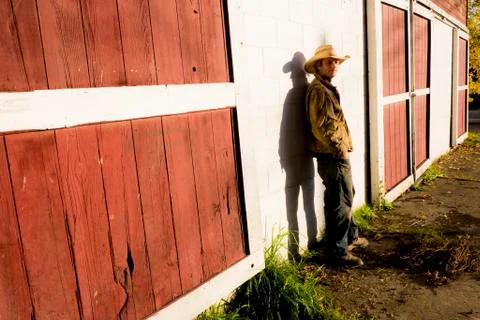 Caucasian farmer leaning on barn wall Stock Photos
