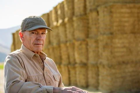 Caucasian farmer near stacks of hay Stock Photos