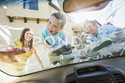Caucasian father and children washing car windshield Stock Photos