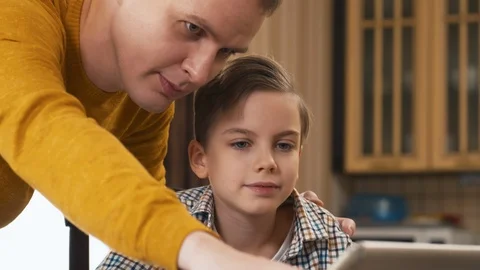 Caucasian father explaining task of homework to son with tablet computer Stock Footage 100688741