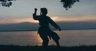 Caucasian Female Athlete Wearing Kimono Practicing Karate Near Large Lake Stock Footage