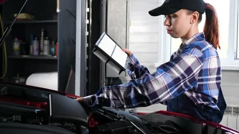 Caucasian female auto mechanic changes the engine air filter in the car. Stock Footage 236820526