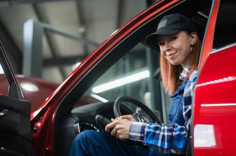 Caucasian female auto mechanic uses a special computer to diagnose faults. Stock Photos