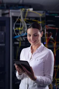 Caucasian female engineer smiling while using digital tablet in computer server Foto stock