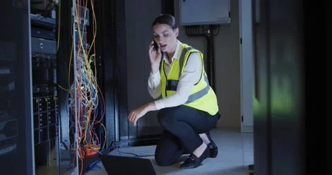 Caucasian female it technician using smartphone and laptop checking computer ser Stock Footage 165134305