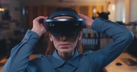 Caucasian female professional puts on augmented reality AR hololens headset Stock Footage