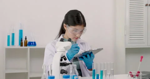 Caucasian female student taking notes on a tablet while wearing safety gogg.. Stock Footage 297553033