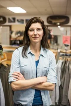Caucasian female trying on a new travel shirt in a retail fly fishing shop. Stock Photos