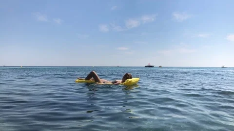 Caucasian female on yellow inflatable mattress slow motion Stock Footage